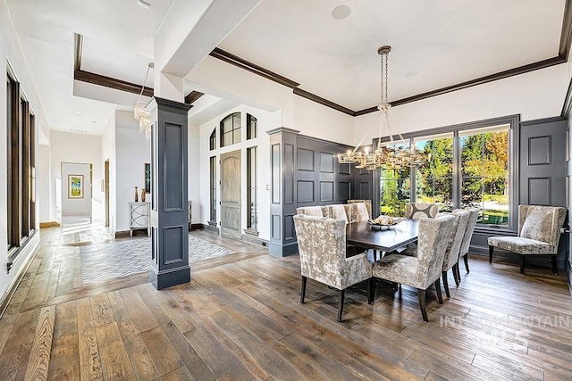 dining room featuring crown molding, a high ceiling, a chandelier, and hardwood / wood-style floors
