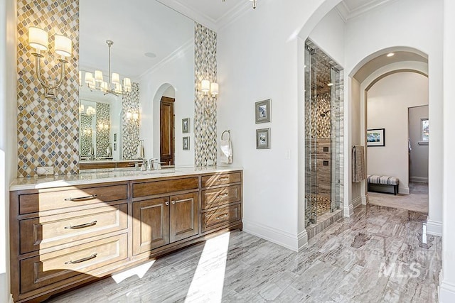 full bath with crown molding, vanity, a chandelier, baseboards, and a shower stall