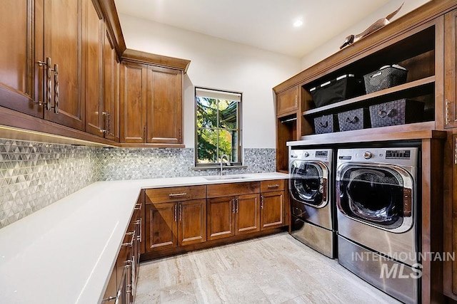 laundry area featuring a sink, cabinet space, and washing machine and clothes dryer