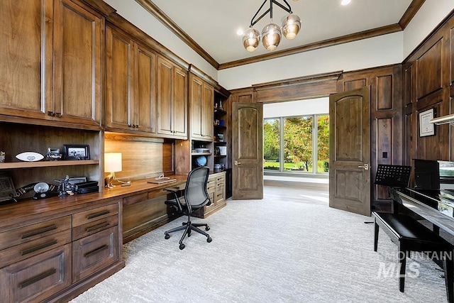 home office featuring crown molding, light carpet, built in desk, and a chandelier