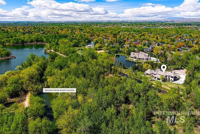 bird's eye view with a water view and a wooded view