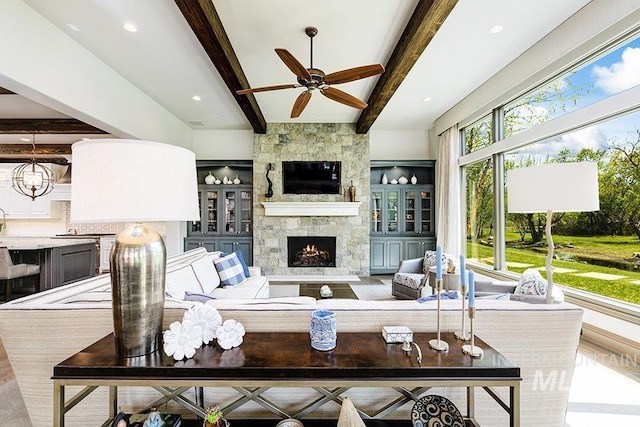 living area with recessed lighting, a ceiling fan, beam ceiling, and a fireplace