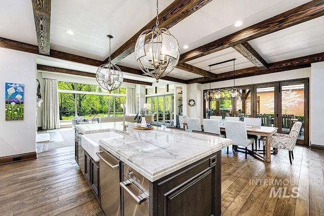 kitchen with a sink, baseboards, hardwood / wood-style flooring, and a chandelier