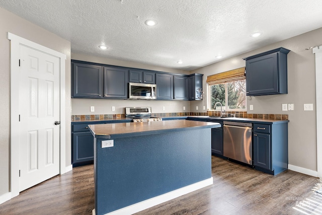2801 W Lost Rpds, Meridian, ID 83646 - kitchen featuring blue cabinets, a sink, dark wood-style floors, and stainless steel appliances