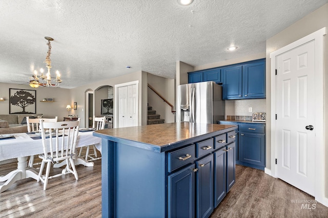 2801 W Lost Rpds, Meridian, ID 83646 - kitchen featuring arched walkways, stainless steel refrigerator with ice dispenser, blue cabinets, and dark wood-style floors