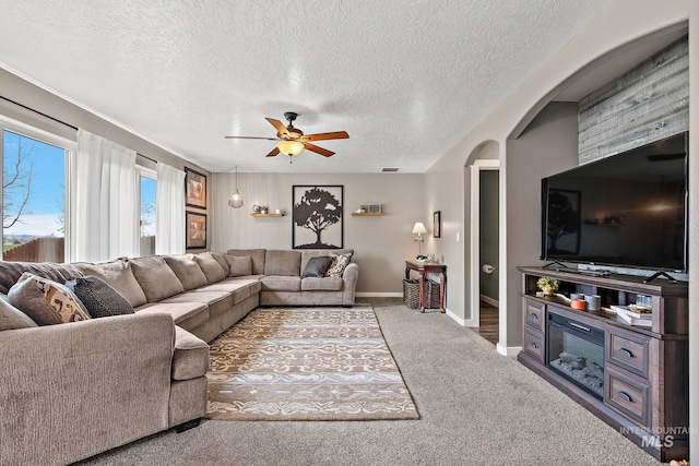 2801 W Lost Rpds, Meridian, ID 83646 - living area featuring baseboards, a textured ceiling, carpet floors, ceiling fan, and arched walkways