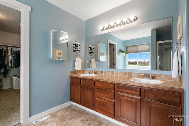 2801 W Lost Rpds, Meridian, ID 83646 - bathroom featuring baseboards, double vanity, a sink, and visible vents