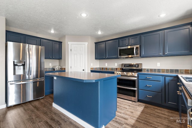 2801 W Lost Rpds, Meridian, ID 83646 - kitchen with a center island, dark wood finished floors, recessed lighting, stainless steel appliances, and blue cabinets