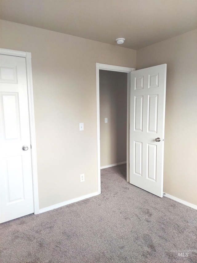 unfurnished bedroom with carpet floors and baseboards