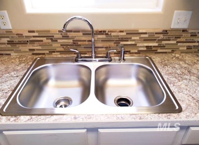 details with decorative backsplash and a sink