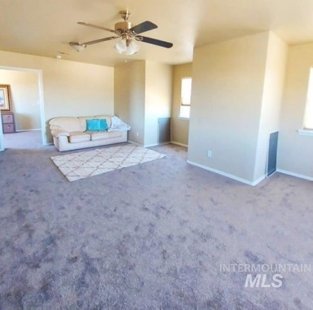 unfurnished living room featuring a ceiling fan, baseboards, and carpet