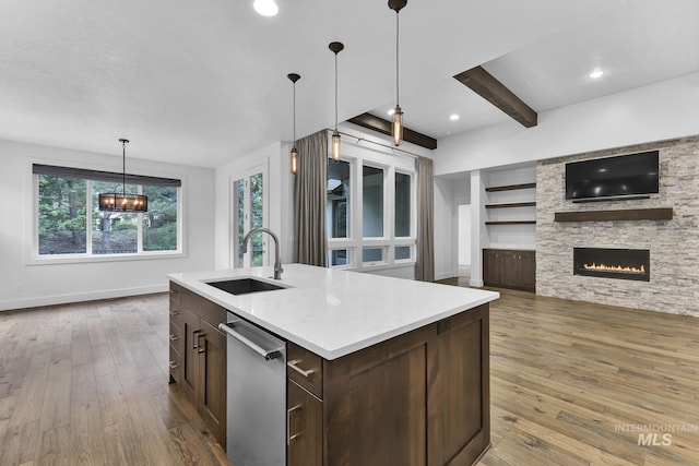 kitchen featuring a sink, dishwasher, wood-type flooring, dark brown cabinets, and light countertops