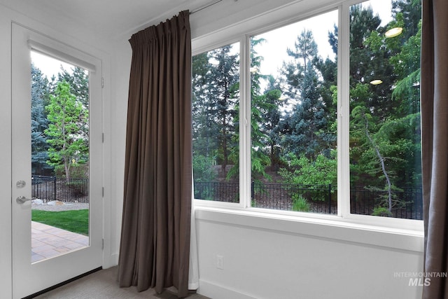 doorway to outside featuring carpet floors and baseboards