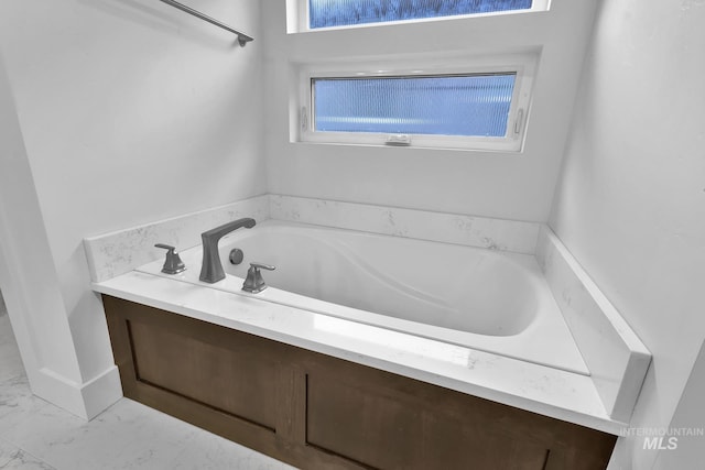 full bath featuring a garden tub and marble finish floors
