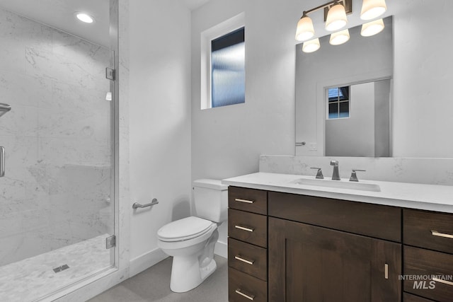 full bathroom with a shower stall, toilet, vanity, and plenty of natural light