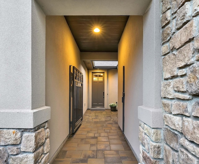 property entrance featuring stucco siding and stone siding
