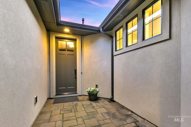 view of exterior entry featuring stucco siding