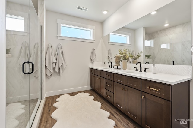 full bath with wood finished floors, a sink, visible vents, and a healthy amount of sunlight