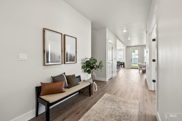 hallway featuring light wood-style flooring and baseboards