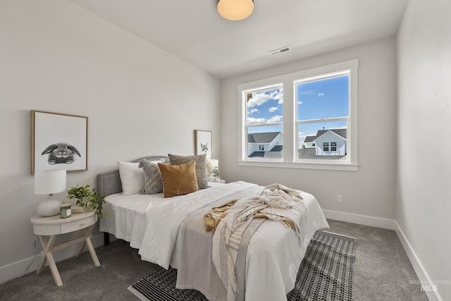 bedroom featuring dark colored carpet, visible vents, and baseboards