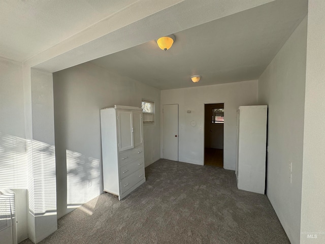 unfurnished bedroom featuring dark carpet