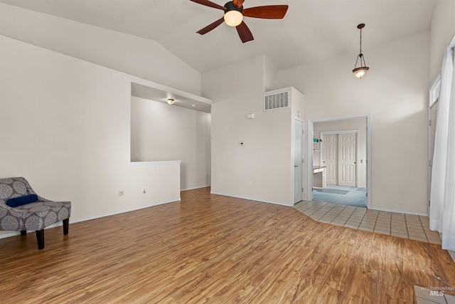 2313 River Oaks Ct, Nampa, ID 83686 - unfurnished living room featuring a ceiling fan, light wood-style floors, high vaulted ceiling, and baseboards
