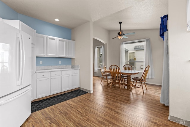 2313 River Oaks Ct, Nampa, ID 83686 - kitchen featuring freestanding refrigerator, arched walkways, a ceiling fan, white cabinets, and light countertops