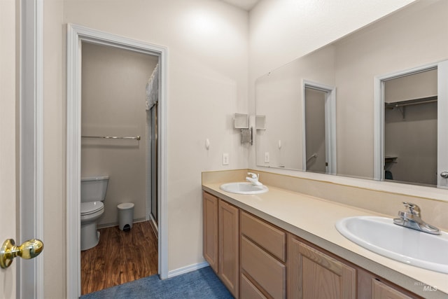 2313 River Oaks Ct, Nampa, ID 83686 - full bathroom with toilet, double vanity, a stall shower, wood finished floors, and a walk in closet