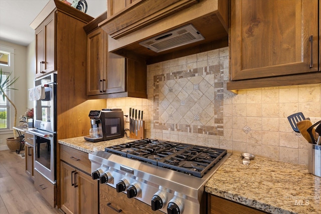550 W Heikes Ln, Eagle, ID 83616 - kitchen with appliances with stainless steel finishes, healthy amount of natural light, tasteful backsplash, and light stone counters