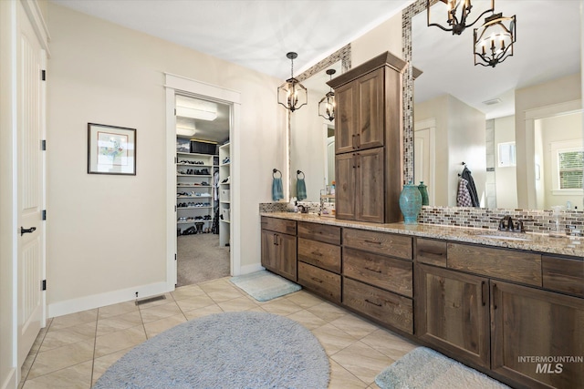 550 W Heikes Ln, Eagle, ID 83616 - full bathroom with a chandelier, double vanity, tile patterned flooring, a walk in closet, and baseboards
