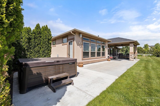 550 W Heikes Ln, Eagle, ID 83616 - rear view of house featuring a hot tub, a patio area, stucco siding, and a lawn