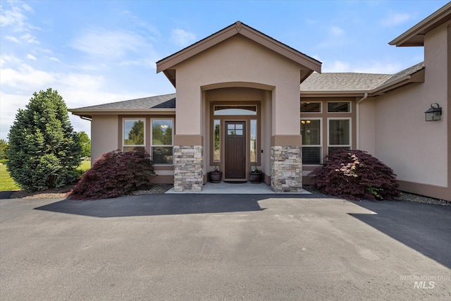 550 W Heikes Ln, Eagle, ID 83616 - view of exterior entry featuring stucco siding, stone siding, and a shingled roof