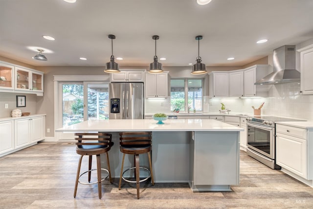 6174 W Winstead Pl, Boise, ID 83704 - kitchen featuring stainless steel appliances, wall chimney exhaust hood, a center island, light wood finished floors, and recessed lighting