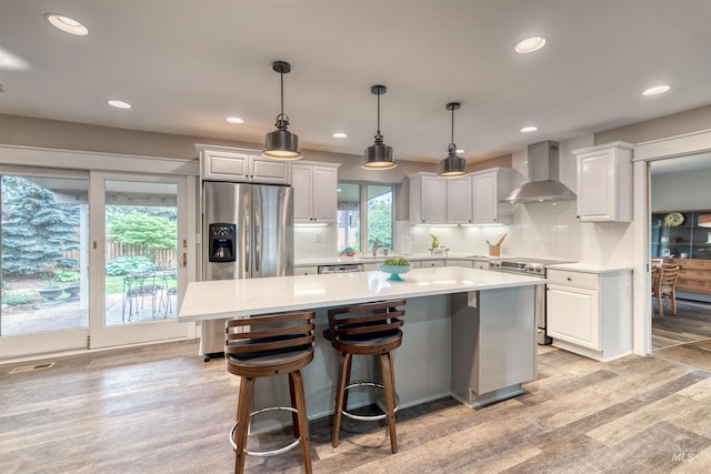 6174 W Winstead Pl, Boise, ID 83704 - kitchen featuring wall chimney range hood, appliances with stainless steel finishes, light countertops, tasteful backsplash, and white cabinets