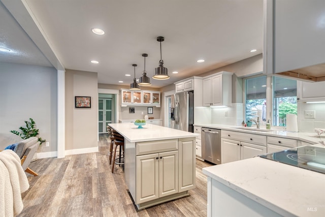 6174 W Winstead Pl, Boise, ID 83704 - kitchen featuring appliances with stainless steel finishes, a sink, light wood-style flooring, recessed lighting, and a kitchen island