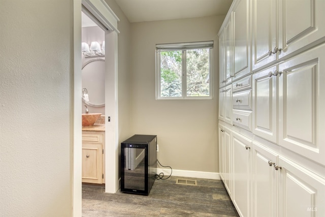 6174 W Winstead Pl, Boise, ID 83704 - washroom featuring dark wood-style floors, baseboards, and wine cooler