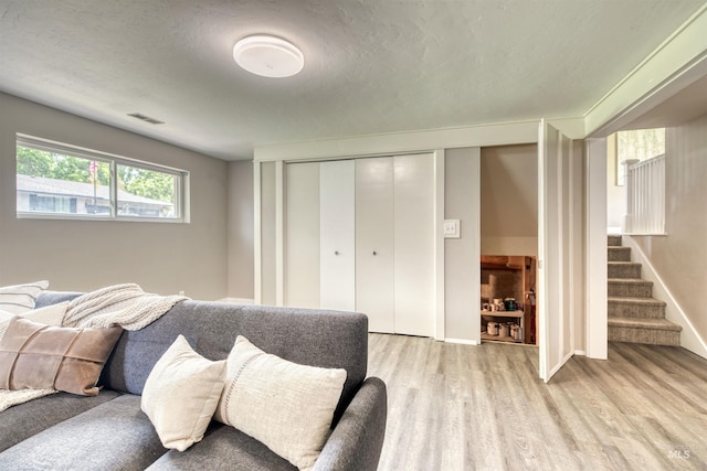 6174 W Winstead Pl, Boise, ID 83704 - living room featuring light wood-style flooring, stairway, baseboards, and a textured ceiling