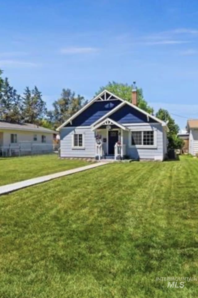 view of front of home with a front yard and a chimney