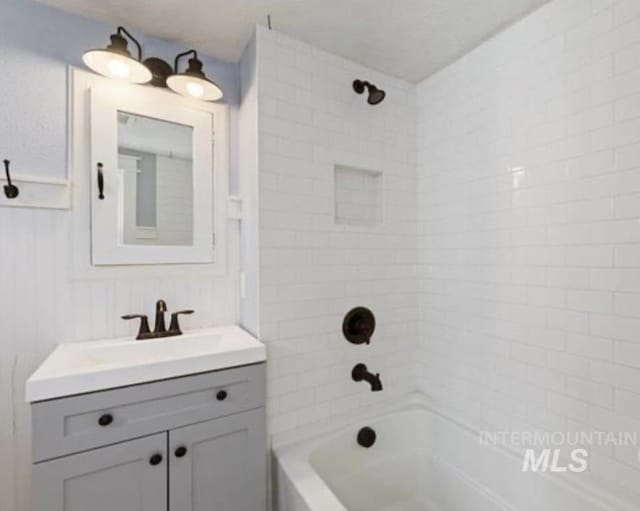 bathroom featuring tiled shower / bath combo and vanity