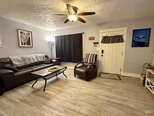 living room with a textured ceiling, light hardwood / wood-style flooring, and ceiling fan