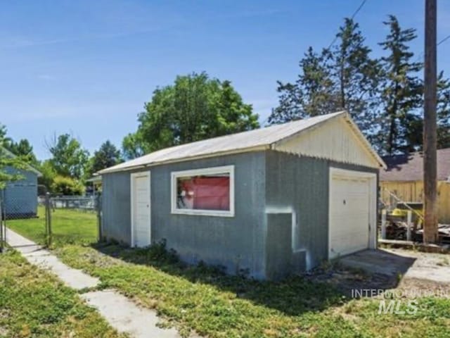 view of outdoor structure featuring fence and an outbuilding