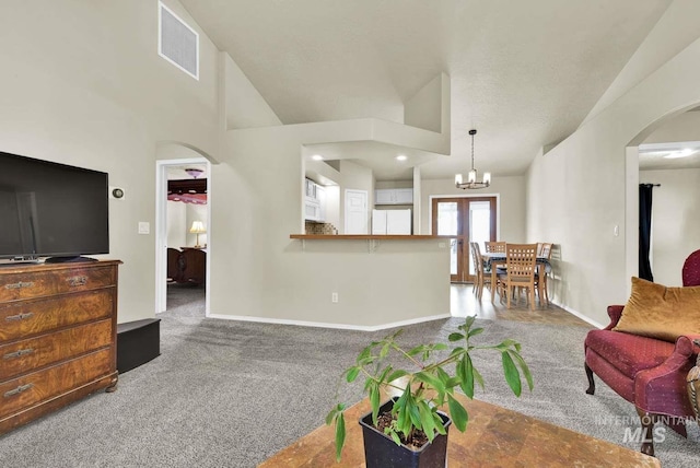 11793 Shelburne, Caldwell, ID 83605 - living room featuring lofted ceiling, visible vents, baseboards, arched walkways, and carpet