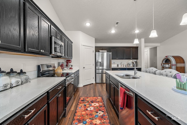 2701 N Ice Fire Pl, Star, ID 83669 - kitchen featuring stainless steel appliances, a sink, dark wood-style floors, pendant lighting, and dark cabinets