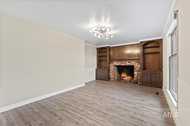 905 S Canyon St, Nampa, ID 83686 - unfurnished living room featuring wood finished floors, a fireplace, a chandelier, and baseboards