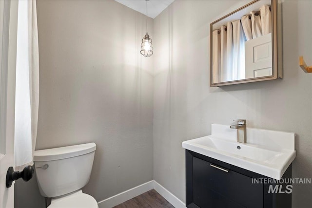 905 S Canyon St, Nampa, ID 83686 - bathroom featuring toilet, vanity, wood finished floors, and baseboards