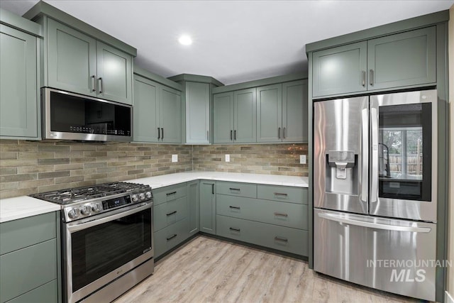 905 S Canyon St, Nampa, ID 83686 - kitchen featuring appliances with stainless steel finishes, light wood-style floors, tasteful backsplash, green cabinetry, and recessed lighting