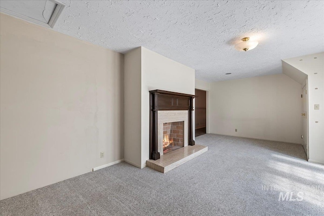 905 S Canyon St, Nampa, ID 83686 - unfurnished living room featuring light colored carpet, a warm lit fireplace, and a textured ceiling