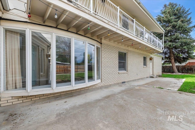 905 S Canyon St, Nampa, ID 83686 - view of side of home featuring a balcony, brick siding, and a patio