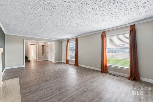 905 S Canyon St, Nampa, ID 83686 - unfurnished living room featuring wood finished floors, a textured ceiling, stairs, ornamental molding, and baseboards