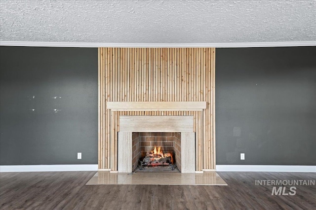 905 S Canyon St, Nampa, ID 83686 - detailed view of ornamental molding, wood finished floors, baseboards, a warm lit fireplace, and a textured ceiling